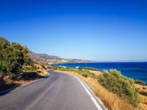 Asphalt road running along the sea near Heraklion, Crete, under a clear sky