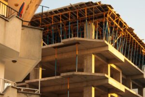 Concrete building under construction with scaffolding in warm evening light