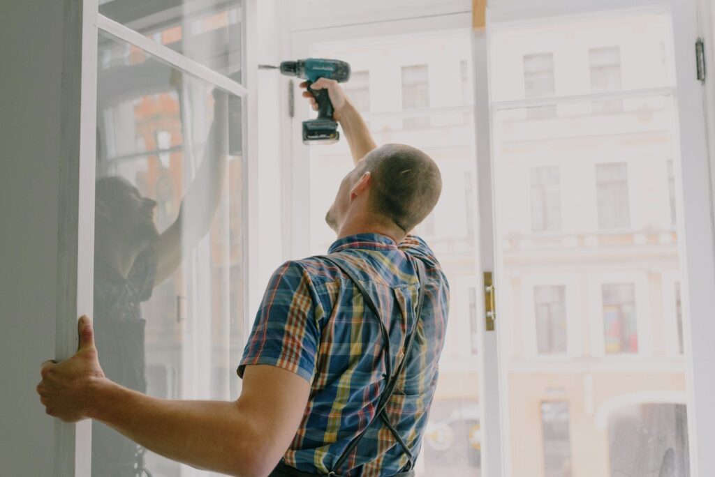 Worker drilling a window frame during a home renovation