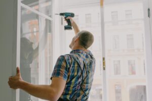 Worker drilling a window frame during a home renovation